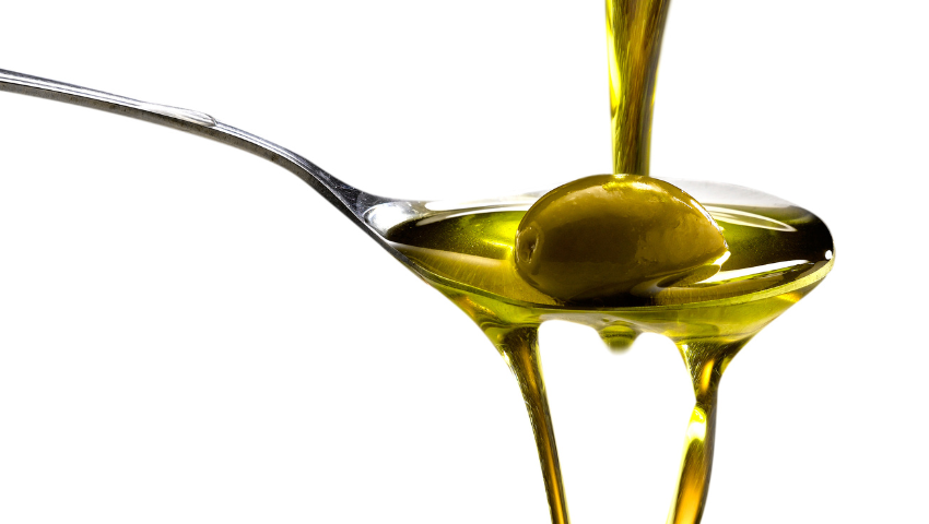 Huile d’olive coulant dans une cuillère avec olives, patrimoine oléicole de Mouriès en Provence.